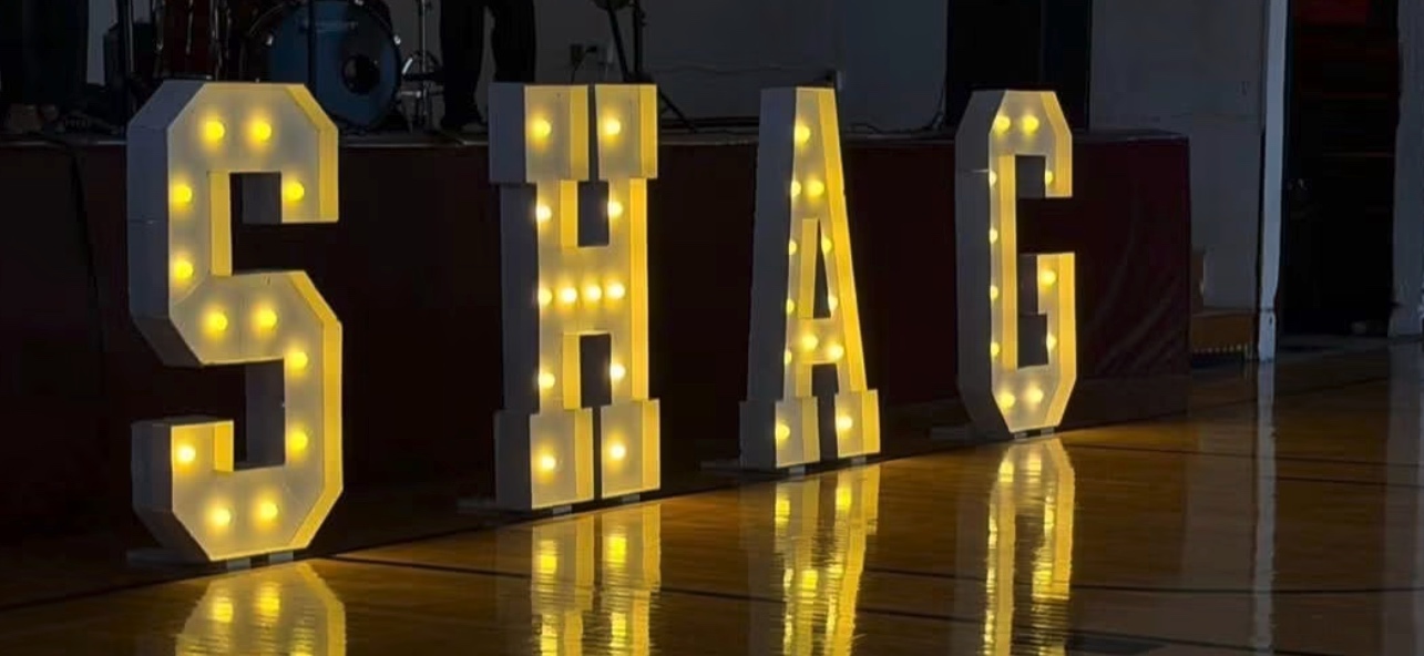 Illuminated marquee letters spelling SHAG on the dance floor at a Your Shag Club event